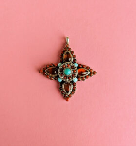 Tibetan gau case with brown stones, coral, and turquoise.