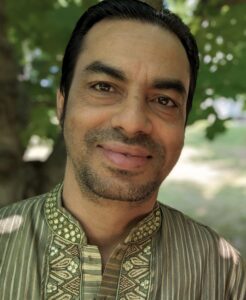 Man wearing Nepali clothing in garden.