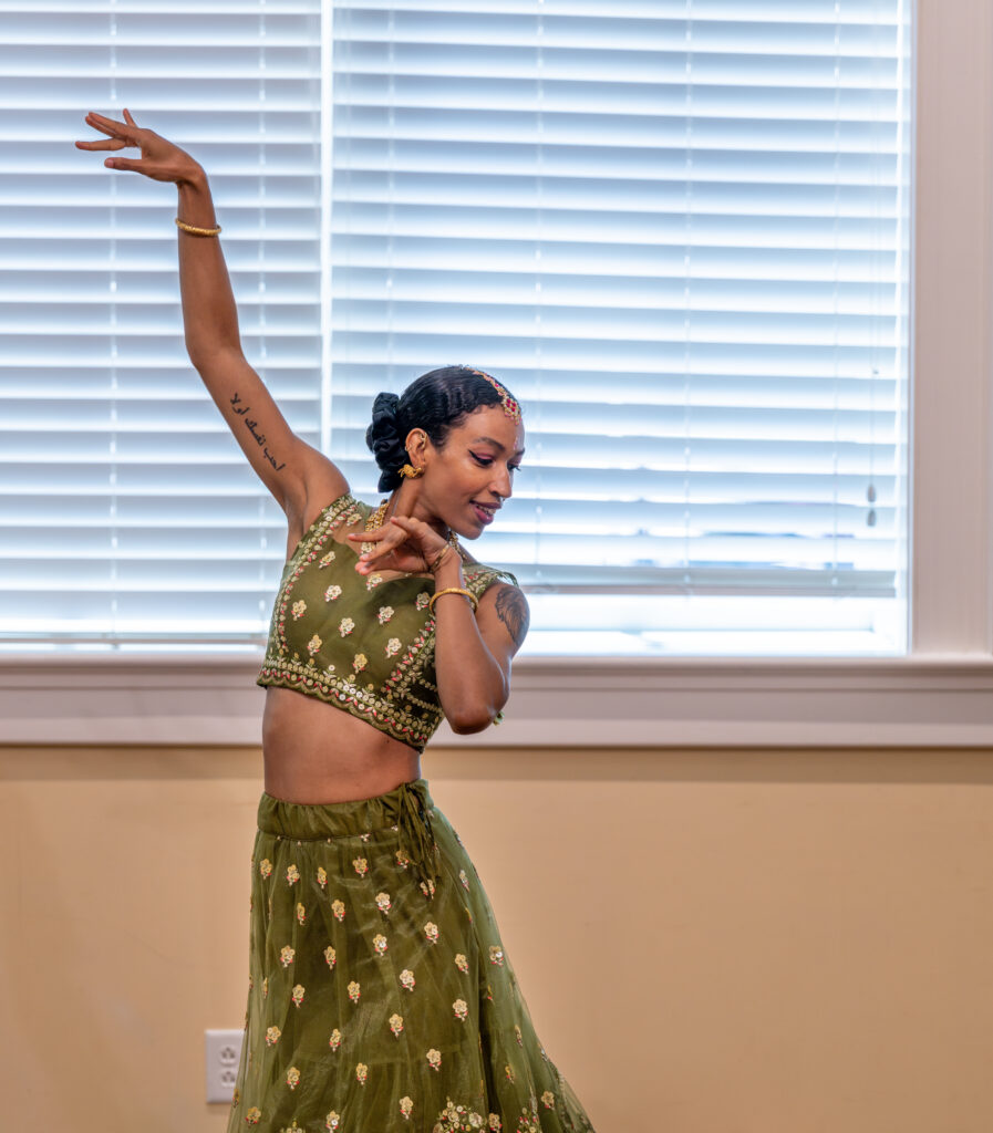 Girl in dance pose in green lehenga.