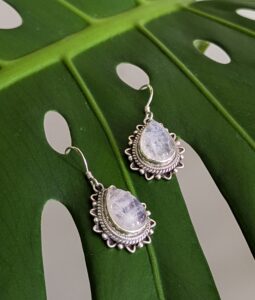Large moonstone earrings on a leaf.