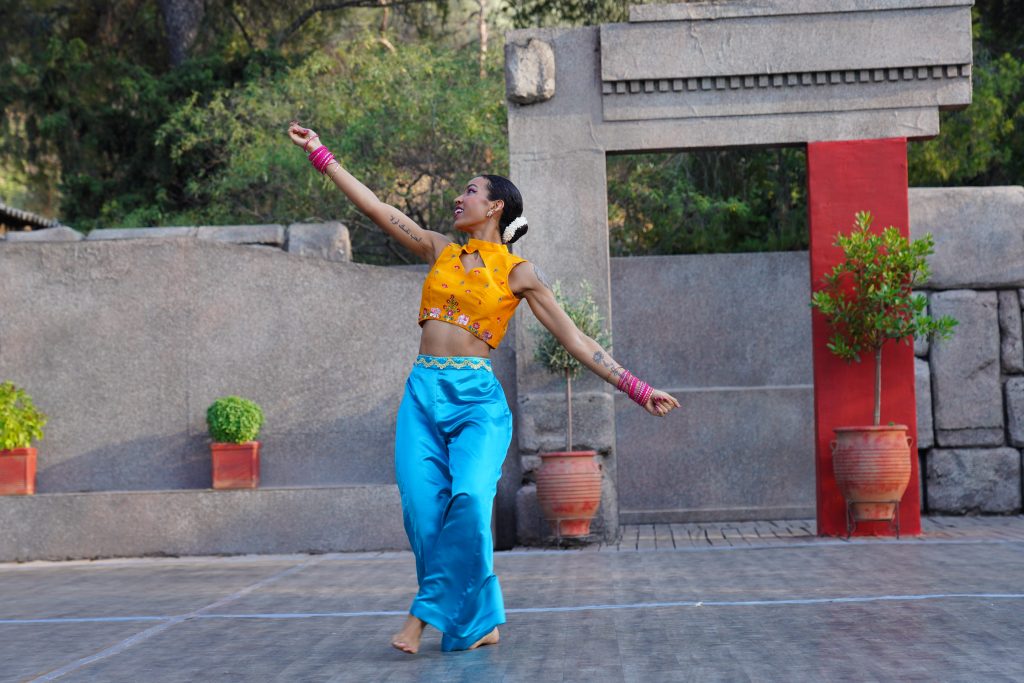 Woman dancing in blue and yellow costume.